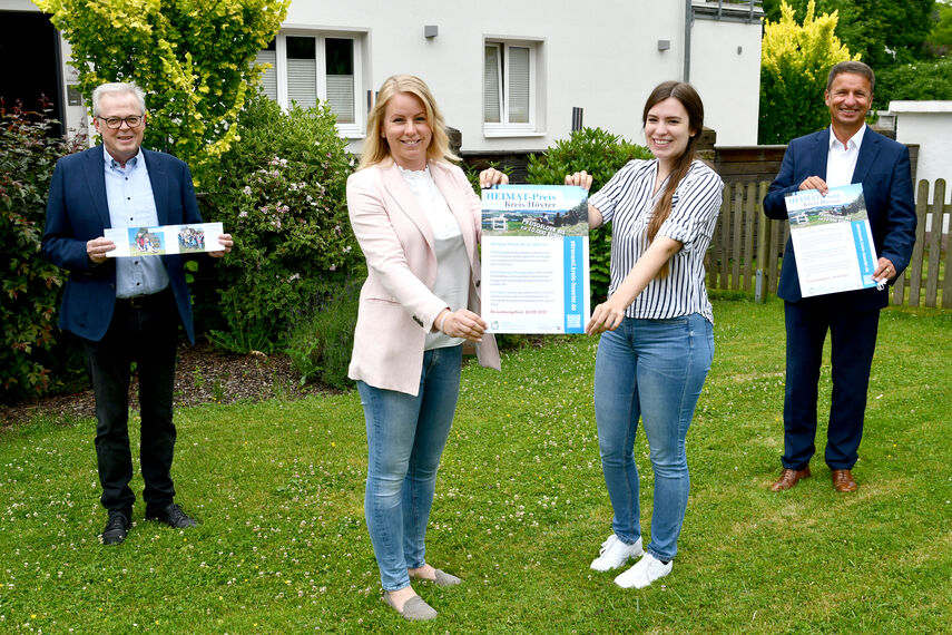 Klaus Schumacher, Katharina Serinelli, Dorina Bernsmann und Landrat Michael Stickeln halten ein Plakat für den Heimatpreis in der Hand.